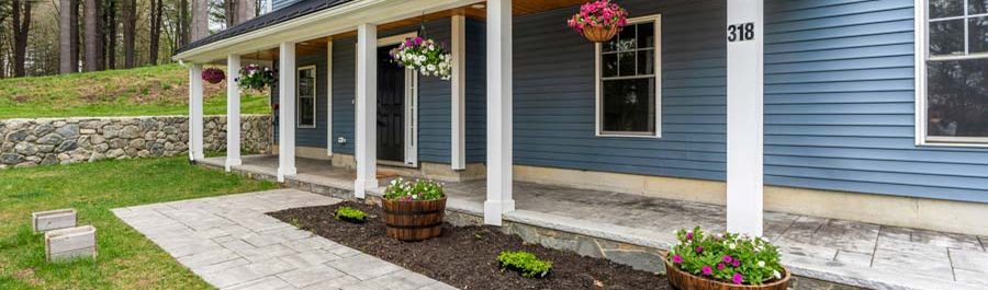 A blue clapboard home with a full-width farmer’s porch