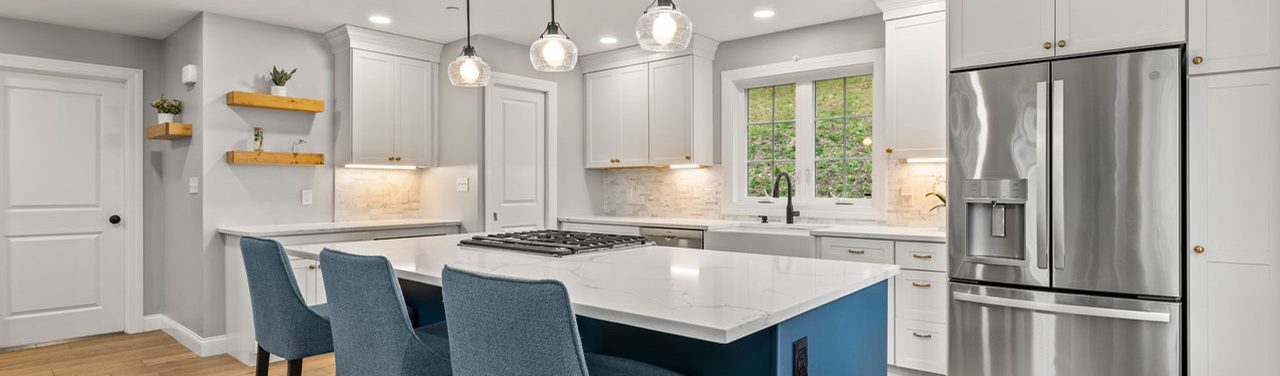 A remodelled kitchen with a navy island and pendant lighting